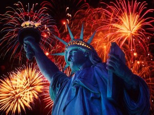 Statua della Libertà con fuochi d'artificio sullo sfondo.